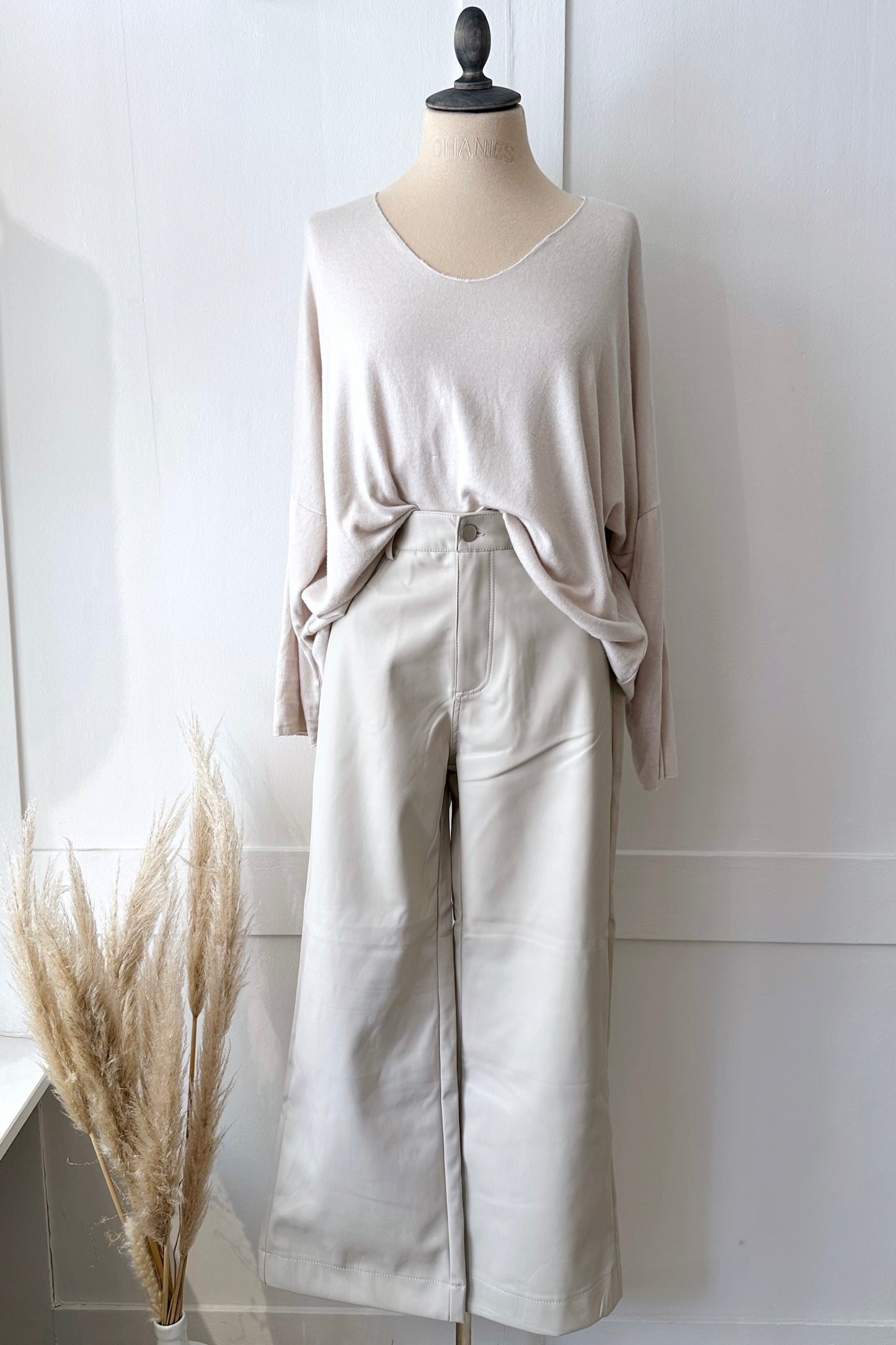 Vegane Lederhose in Stone mit weitem Bein und hohem Bund, kombiniert mit hellem Strickpullover