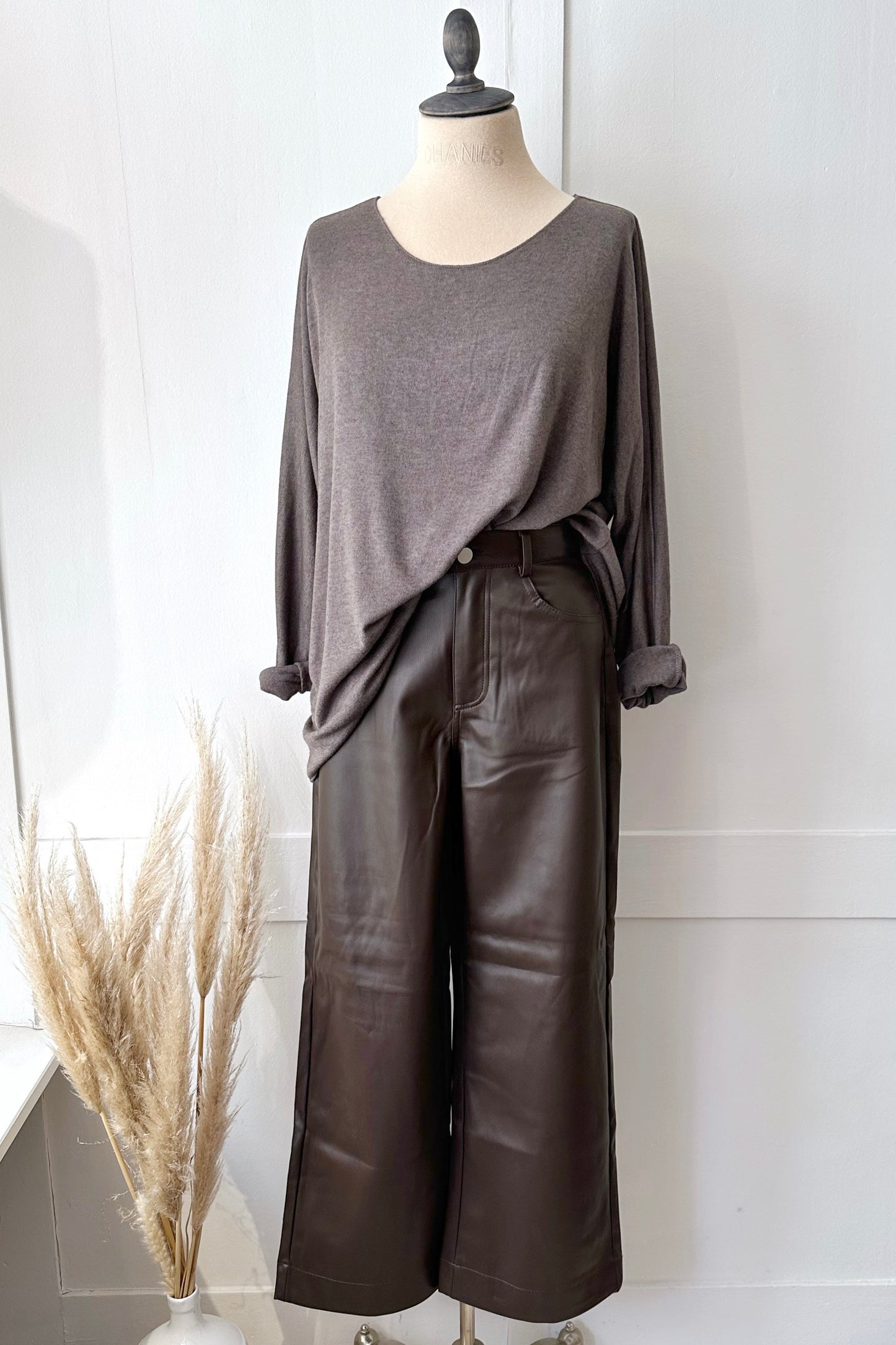 Vegane Lederhose in Braun mit weitem Bein und hohem Bund, kombiniert mit braunen Strickpullover